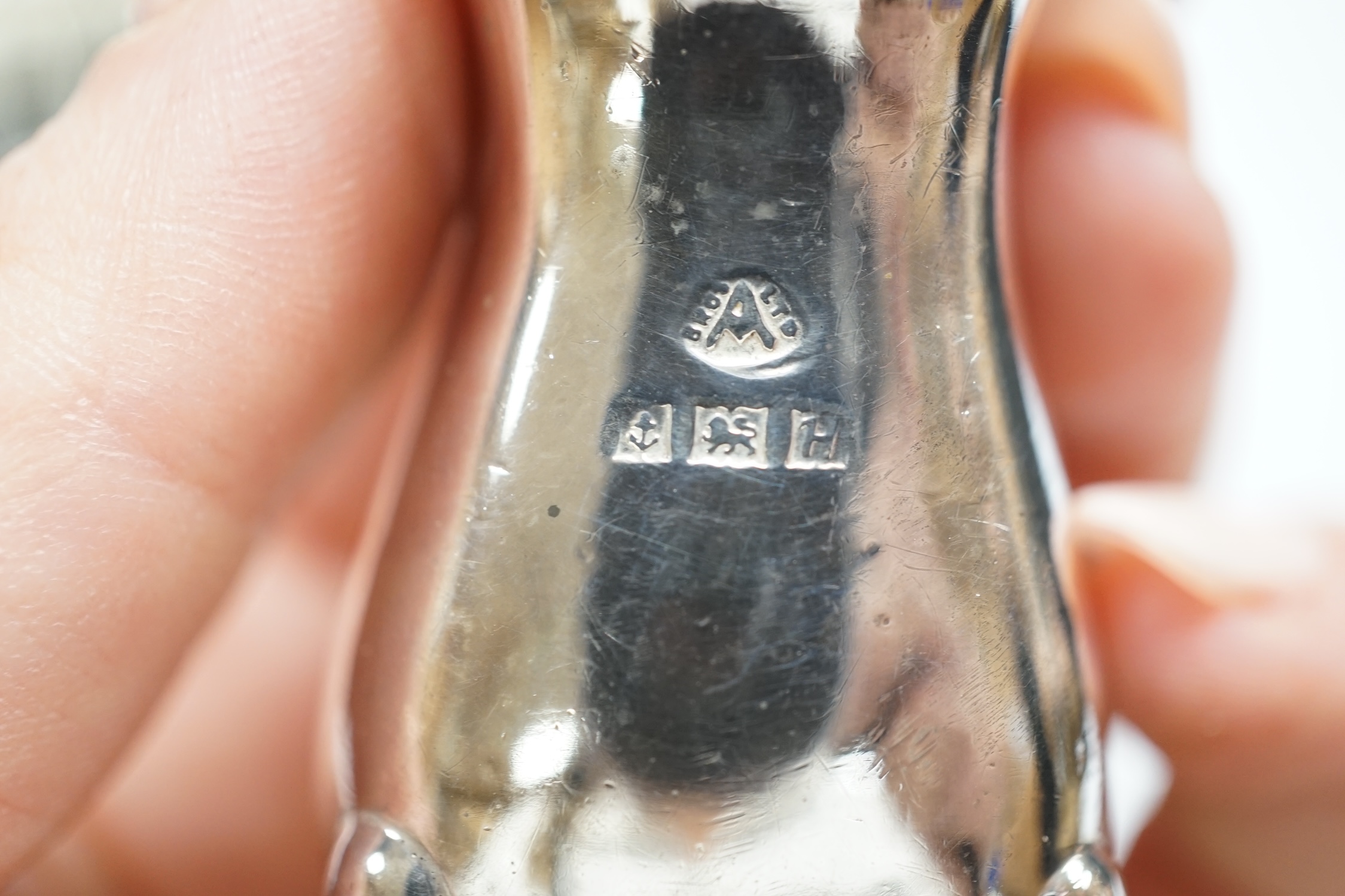 Two cased sets of six silver coffee spoons, a set of four silver condiments, two silver napkin rings, silver toastrack, etc.